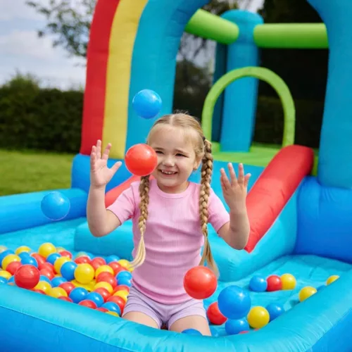 Szivárványszínű ugrálóvár csúszdával és labdamedencével